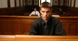 Portrait of a young judge sitting in the courtroom and looking at camera