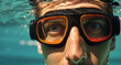 Portrait of a young man in a diving mask and goggles swimming underwater