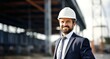 business, building, construction and people concept - smiling businessman in hardhat and suit outdoors