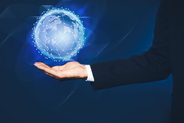 Wall Mural - global innovation. businessman holding virtual planet on dark blue background, closeup