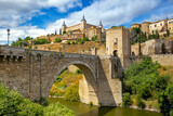 Fototapeta Uliczki - Cityscape of Toledo with the Alcantara bridge in the forefront, Toledo, Spain