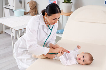 Sticker - Female pediatrician listening to little baby with stethoscope in clinic