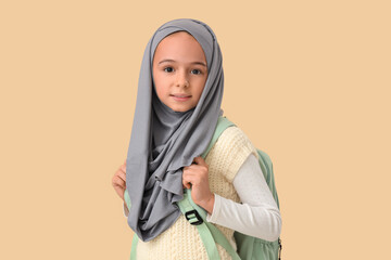 Sticker - Little Muslim girl in hijab with school backpack on beige background