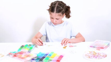 Canvas Print - Young Girl Engrossed in Crafting with Colorful Clay Beads