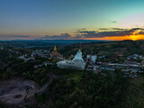 Fototapeta Uliczki - Aerial view amazing Big White Five buddha Statues in sunset. beautiful golden pavilion of Wat Phachonkeaw decorate with jewels and stones on the hill very beautiful and famous landmark in Thailand.