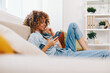 © SHOTPRIME STUDIO - Happy Woman Holding Phone and Relaxing on Sofa at Home