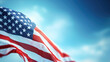 © Kowit - The United States flag waves majestically against a serene blue sky, symbolizing freedom and patriotism.