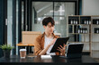 © laddawan - Portrait of a young man sitting at his desk in the office.