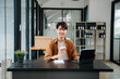 © laddawan - Portrait of a young man sitting at his desk in the office.
