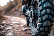 Close-up of the wheel of a motorbike on dirt road