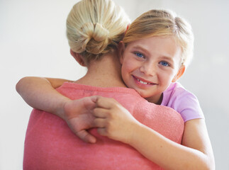 Wall Mural - Mother, girl and hug in portrait, bonding and love in childhood by single parent in studio. Daughter, mommy and caring together on white background, embracing and security or enjoying connection