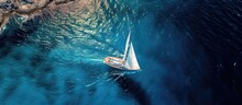 A Panoramic Photo Taken By An Aerial Drone Shows A Stunning Sailboat Sailing In The Deep Blue Sea Near A Mediterranean Port.