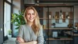 © buraratn - Portrait of young smiling woman looking at camera with crossed arms. Happy girl standing in creative office.