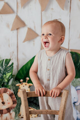 Happy two year old kid having his anniversary photoshooting in a studio. with jungle theme 