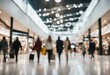 © ArtisticLens - Blurred background of a modern shopping mall with some shoppers Shoppers walking at shopping center
