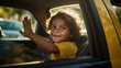A South American child waves from the backseat of a taxi on their way to school