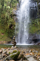 Wall Mural - Small stone tower with pebbles in front of a waterfall in jungle of Boquete in Panama