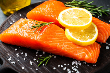 Wall Mural - Salmon fillet with lemon and spices. Raw fish at craft cutting board..