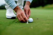 Precision On The Green: A Close-Up Of A Golfer Placing A Ball Marker