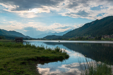 Sticker - Calm alpine lake with sky reflection at the sunset.