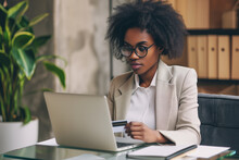 Business Woman Sitting In Front Of A Laptop Using A Credit Card