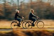 Mature heterosexual couple riding bicycles. Outdoor shot with movement.