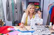 © Krakenimages.com - Young blonde woman tailor smiling confident sitting on table at tailor shop