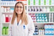 © Krakenimages.com - Young beautiful hispanic woman pharmacist smiling confident standing at pharmacy