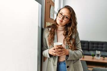 Canvas Print - Young beautiful hispanic woman business worker drinking coffee at office