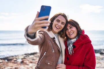 Poster - Two women mother and daughter make selfie by smartphone at seaside