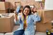 © Krakenimages.com - Young beautiful plus size woman having video call holding key at new home
