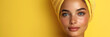 Girl with a yellow towel wrapped around her head against blue background. Image for a facial spa or wellness center, skincare brand. Banner with copy space.