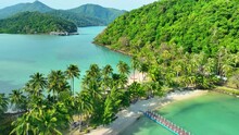 Aerial View Of A Pristine Tropical Island, Where Azure Seas Kiss Golden Sands, Framed By A Vibrant Green Coastline. Natural Wonders Concept. Cinematic Footage. Ko Ngam Island, Thailand. 4K HDR.
