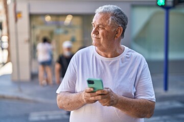 Poster - Middle age grey-haired man smiling confident using smartphone at street