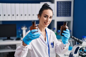 Sticker - Young caucasian woman scientist holding bottles at laboratory