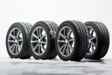 Poster - A row of four tires sitting on top of a snow covered ground. Suitable for winter tire advertisements