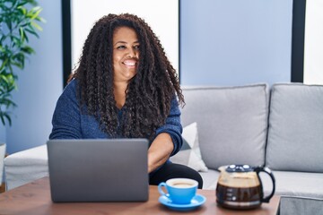 Poster - African american woman using laptop drinking coffee at home