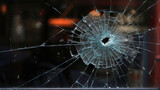 Fototapeta  - Cracked window after a bullet shot.