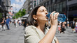 © Krakenimages.com - Young beautiful hispanic woman standing drinking water in the streets of Vienna