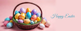 Fototapeta Storczyk - Happy Easter greeting card with colorful decorated eggs in the basket on pink pastel background. Generative AI
