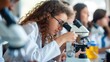 Group of college students performing experiment using microscope in science lab. University focused student looking through microscope in biology class.