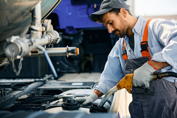 Wall Mural - Truck maintenance mechanic refueling gas tank.