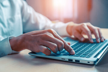 Wall Mural - businessman hand typing on computer keyboard of a laptop computer in office. business and finance co