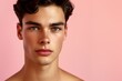© Rudsaphon - Portrait of a handsome young man with a trendy hairstyle   on a soft pink background, exuding confidence.