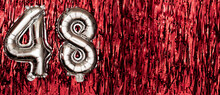 Silver Foil Balloon Number 48 On A Background Of Red Tinsel Decoration. Birthday Greeting Card, Inscription Forty-eight. Anniversary Event. Banner.