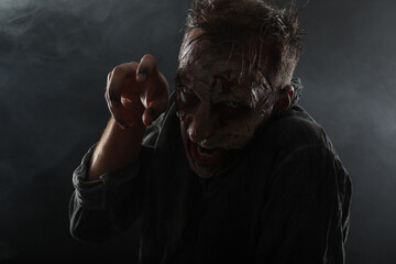 Wall Mural - Scary zombie on dark background. Halloween monster