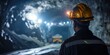 © Attasit - Miner engineer wearing a helmet looking at the mining site