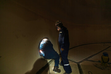 Wall Mural - Male worker inside the  tank storage visual inspection tank into the confined space is the blower
