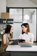 © Nuttapong punna - Two business workers talking on the smartphone and using laptop at the office..