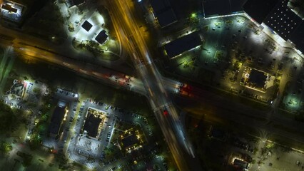Wall Mural - Top view of large multilane road intersection with traffic lights and moving cars in american city at night. Timelapse of transportation system in USA